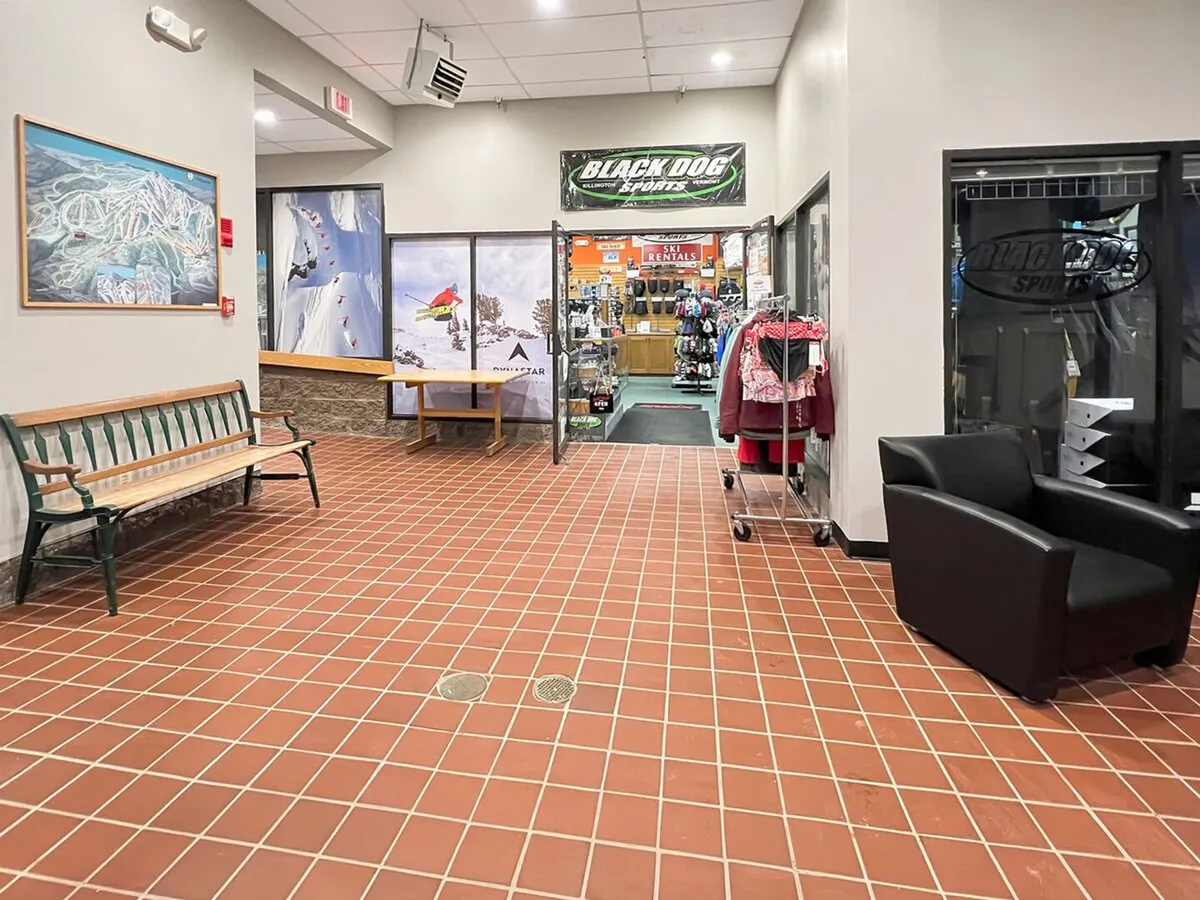 An inviting interior shot of the entrance to Black Dog Sports, Killington’s onsite ski and snowboard shop. The image features bench seating and local artwork, giving a sense of the friendly, convenient shopping experience available right at the resort during winter.